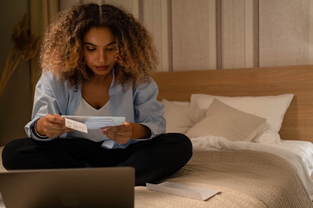 A Woman in Her Bedroom Looking at Some Bills