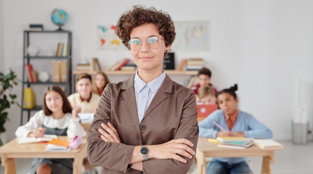 Teacher in Brown Blazer Wearing Eyeglasses Infront of her Students