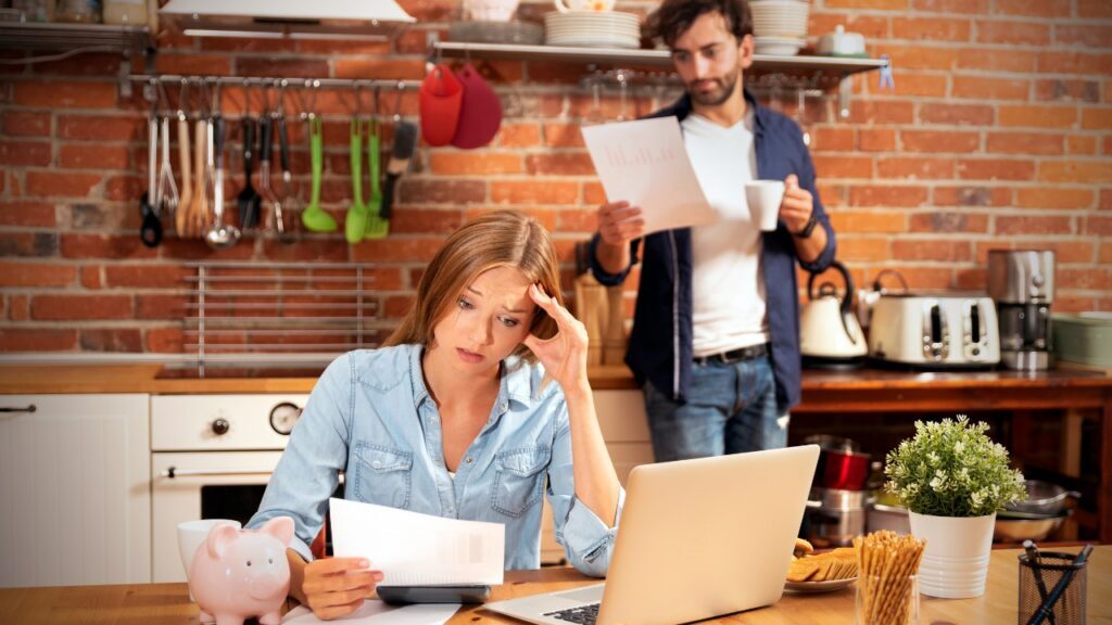 A Couple in the Kitchen Looking over Bills Stressed