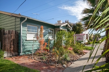 Green bungalow home with drought tolerant landscape inthe fron of 3216 Landis st