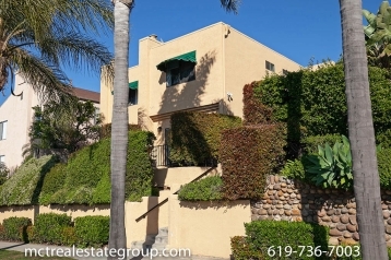beige color exterior of condo complex located 3761 Villa Terrace with staircase and hedges out front