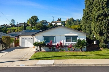 Exterior view of the residential property at 2170 Montclair St, North Park, featuring a white garage, solar panels, and manicured front lawn.